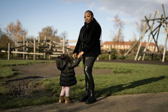 A mother and a child holding hands in the park